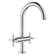 Chrome bathroom faucet with curved spout and two cross-handle controls on round base.