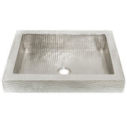 Rectangular hammered copper bathroom sink with single drain hole, viewed from above.