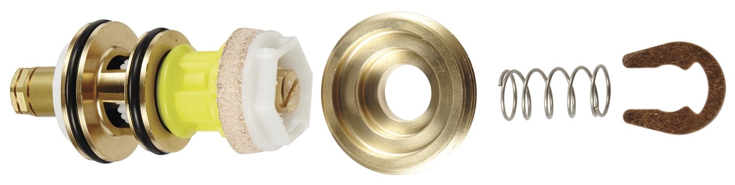 Grohe brass valve components including cartridge, seals, spring, and retaining clip arranged in a row.