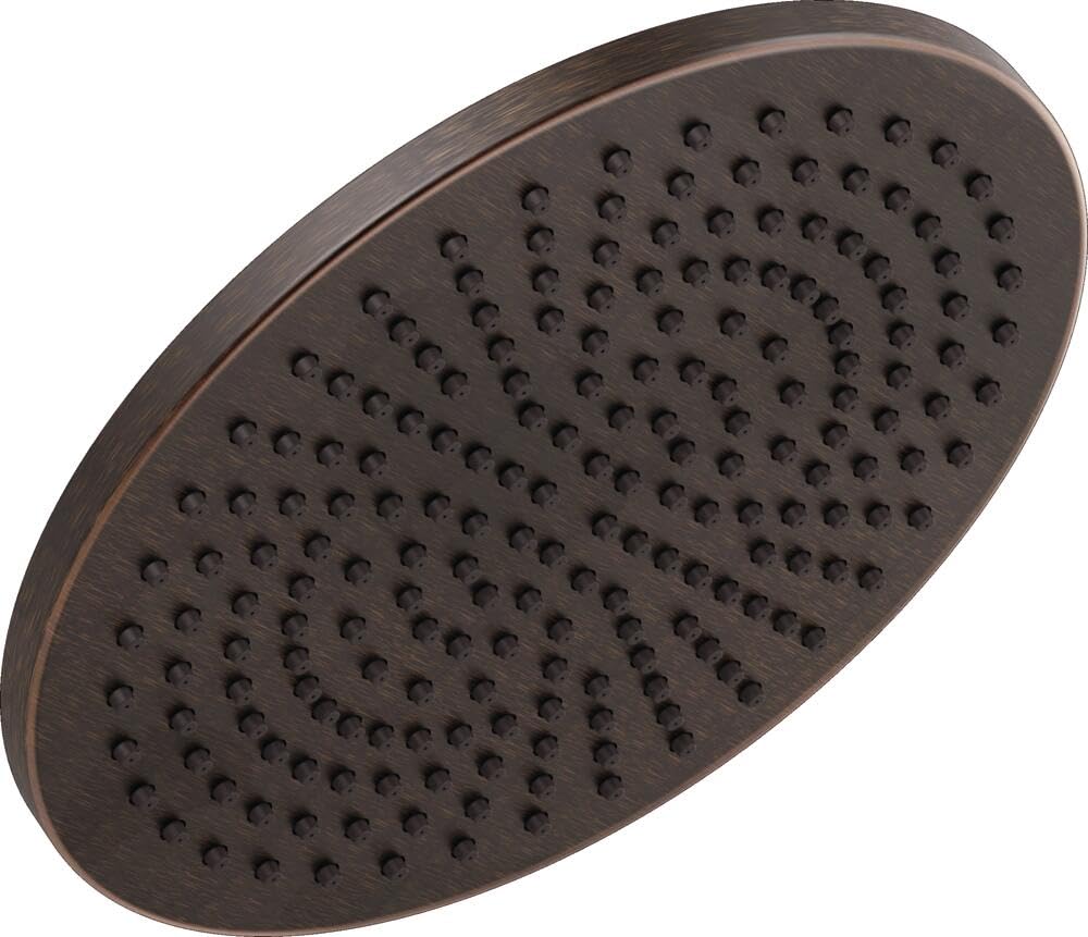 Circular bronze metal raincan shower head with multiple small holes throughout flat surface.