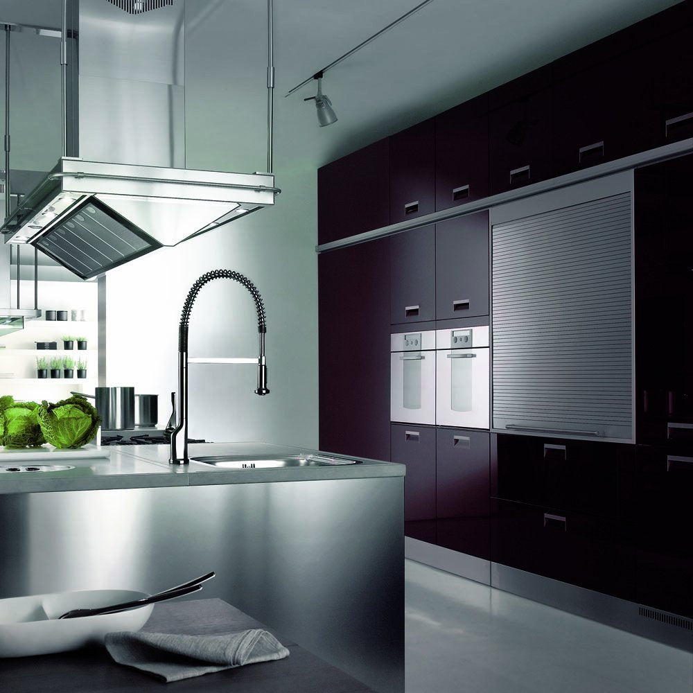 Chrome kitchen faucet with curved pull-down spray head mounted on stainless steel sink counter.