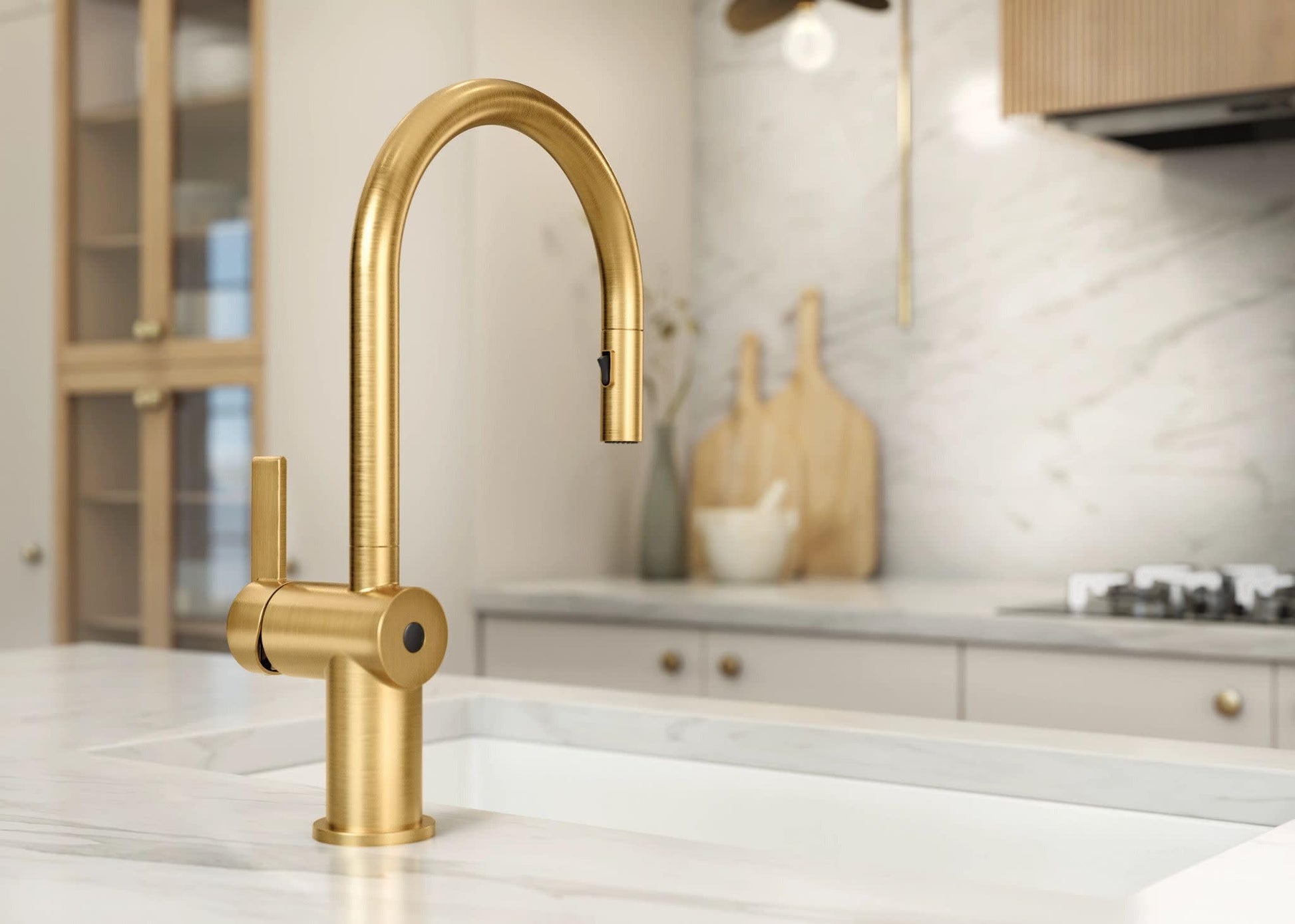 Brushed gold pulldown kitchen faucet with single handle and curved spout installed on white countertop.