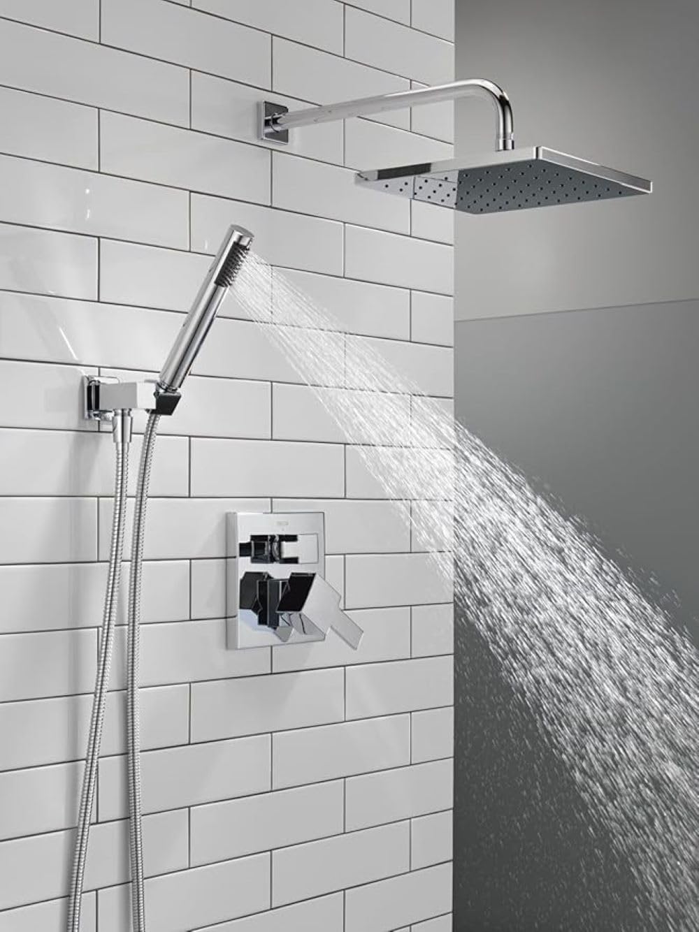 Chrome shower system with square raincan showerhead, hand shower, and wall-mounted valve on subway tile.