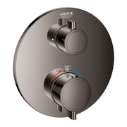 Dark gray round thermostatic valve trim with two circular handles, temperature dial showing 38°C, and Grohe branding.