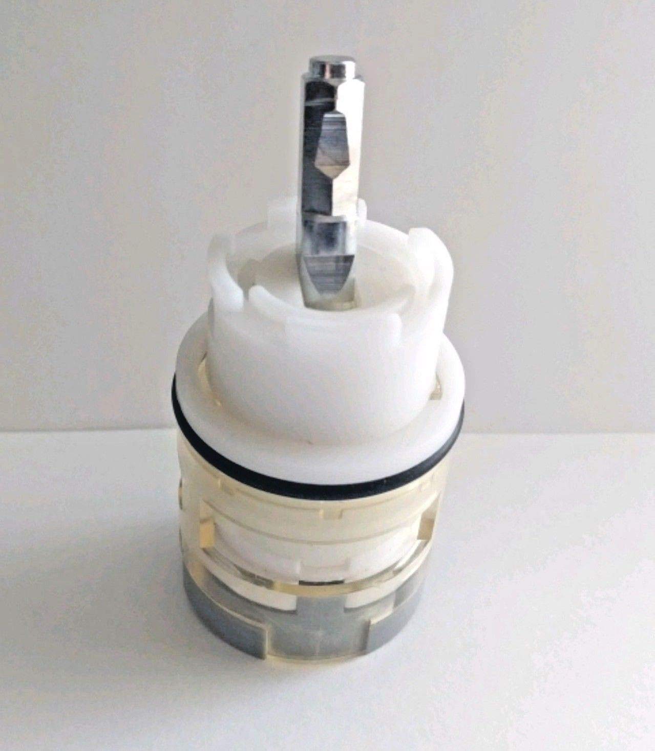 White and gray ceramic cartridge with metal stem, stacked internal components, and black rubber seal ring.