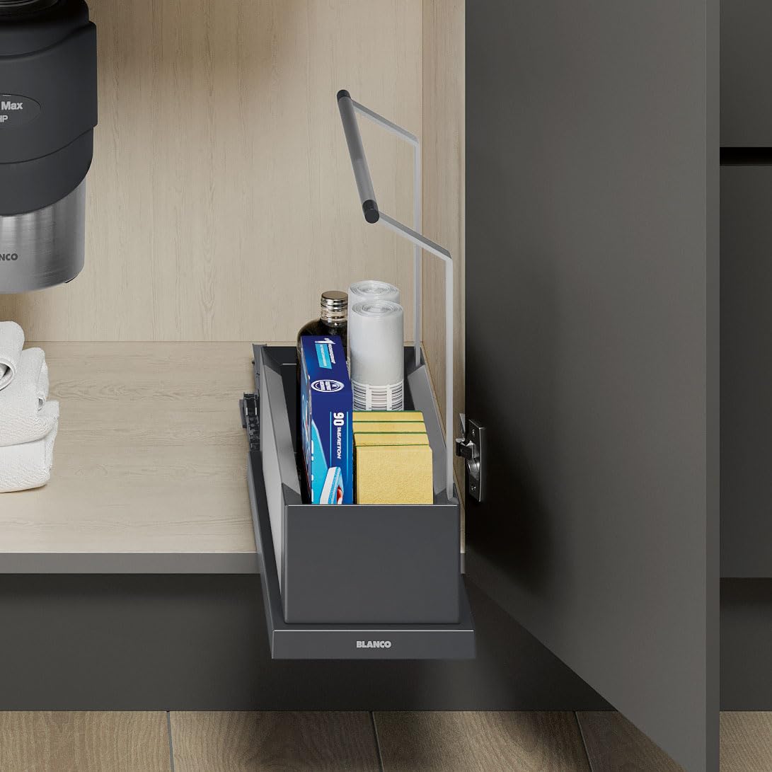 Black storage caddy with handle holding cleaning supplies and paper towels on a kitchen counter.