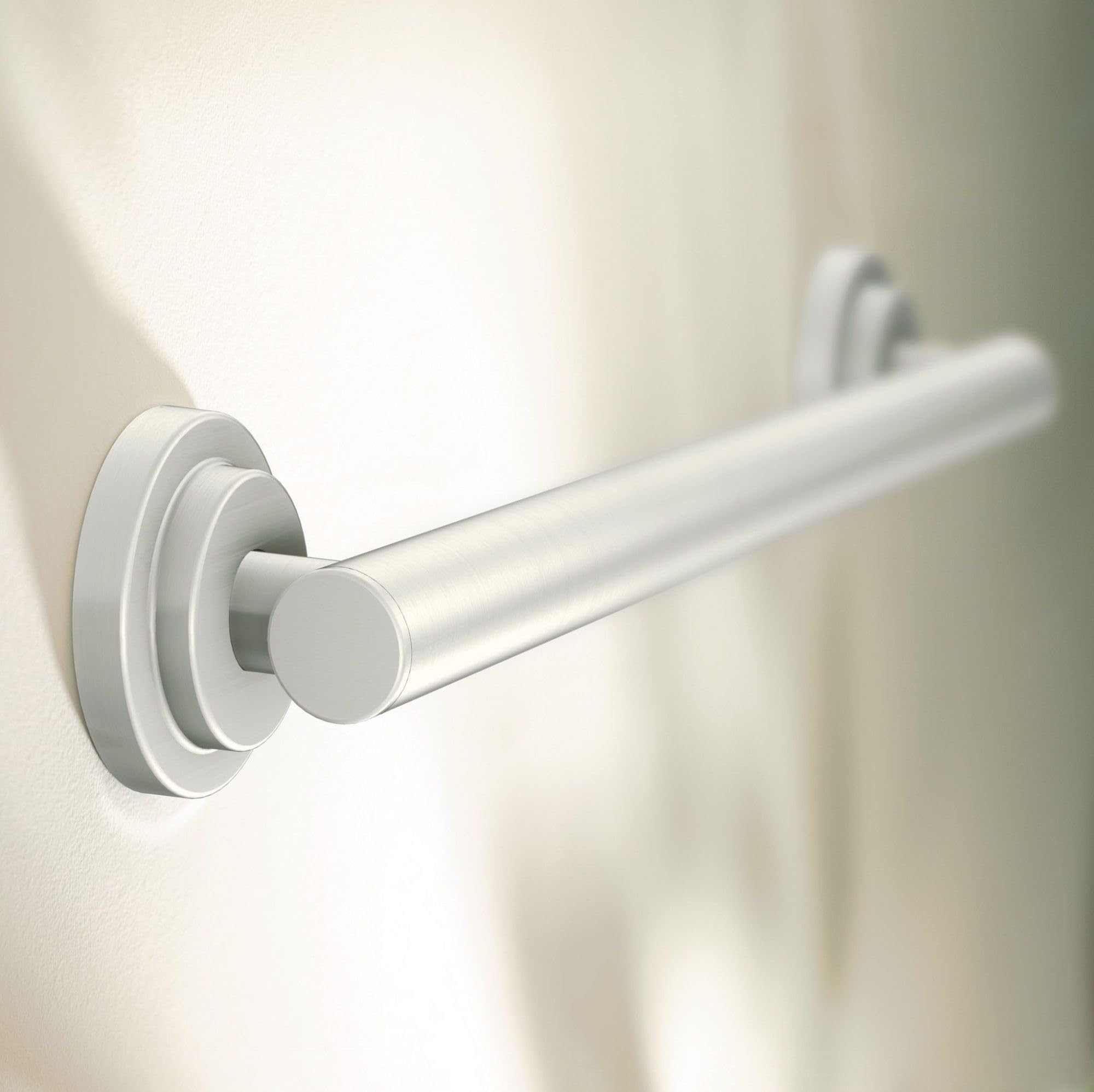 Brushed nickel cylindrical grab bar with circular mounting flanges installed on a wall.