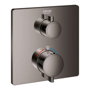 Grohe thermostatic valve trim with two round handles and temperature dial on dark graphite square plate.