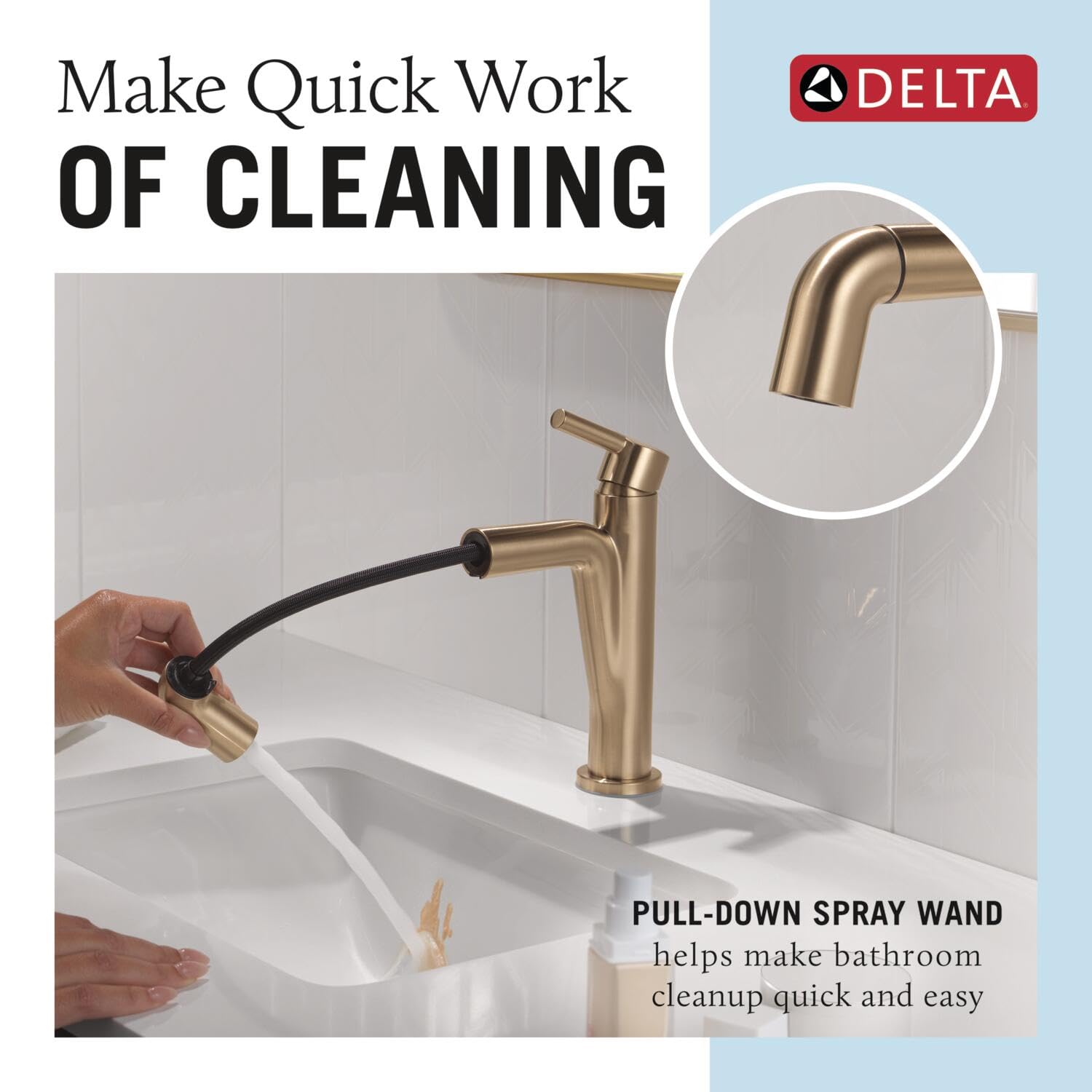 Champagne bronze single-handle bathroom faucet with pull-down spray wand over white sink.