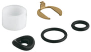 Grohe repair kit containing white plastic seal, brass valve component, and three black rubber seals.