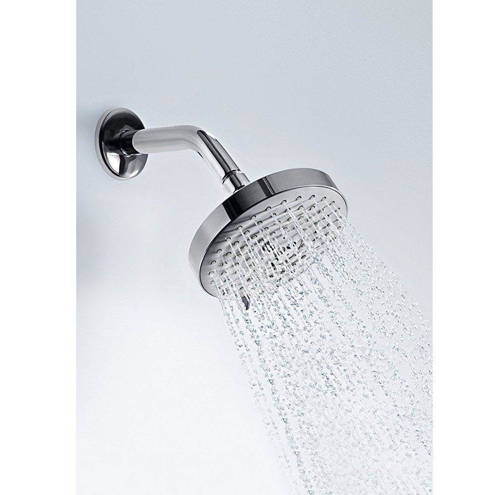 Brushed nickel shower head with curved arm mounted on wall, dispensing water in multiple streams.