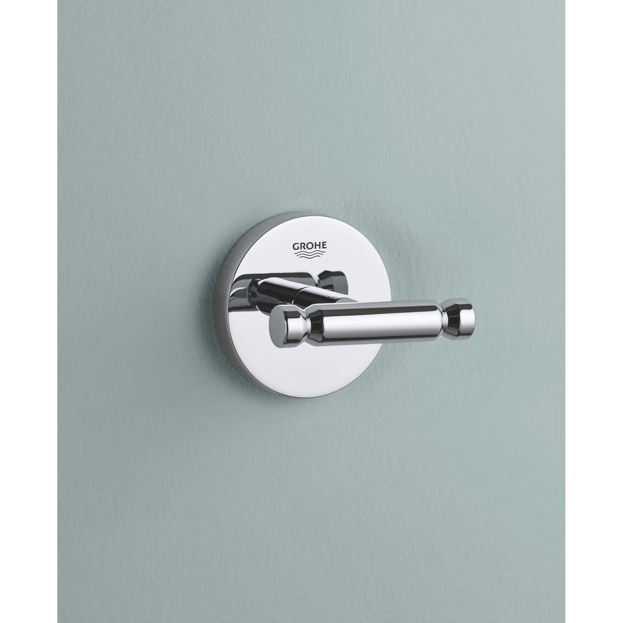 Chrome robe hook with circular wall mount and cylindrical lever handle mounted on light blue wall.