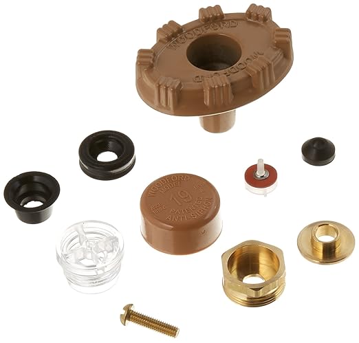 Tan plastic vacuum breaker cap with brass and rubber replacement components including washers, springs, and fasteners.