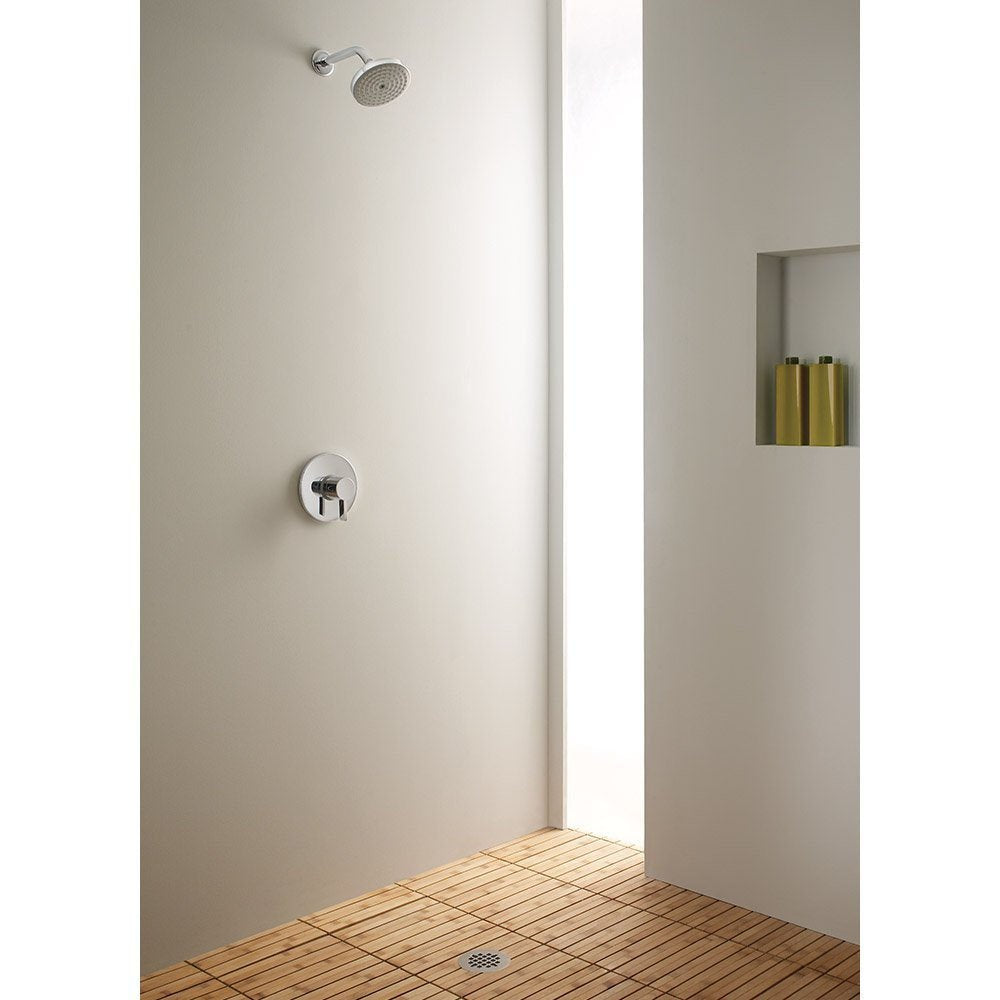 Brushed nickel round showerhead mounted on white tile wall above valve control in shower enclosure.