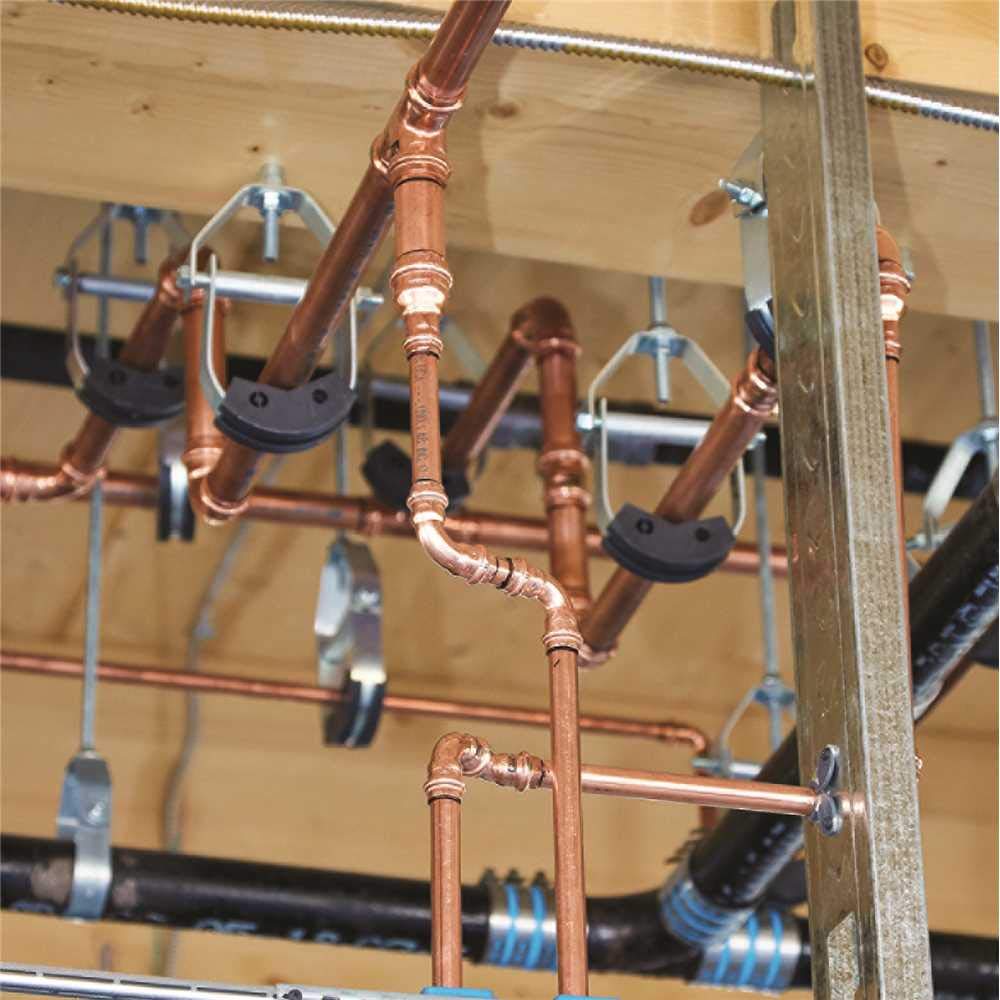 Copper ProPress reducer fitting installed in plumbing system with vertical and horizontal copper pipes.