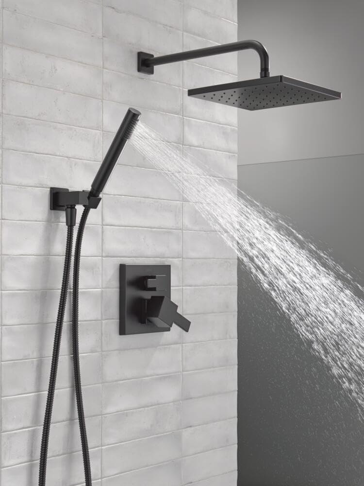 Matte black shower system with square raincan showerhead, hand shower with hose, and wall-mounted valve on white subway tile.