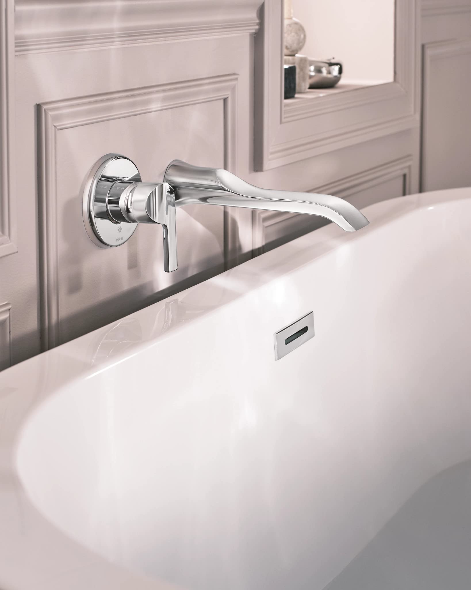 Chrome wall-mounted tub faucet with single lever handle and curved spout installed above a freestanding bathtub.