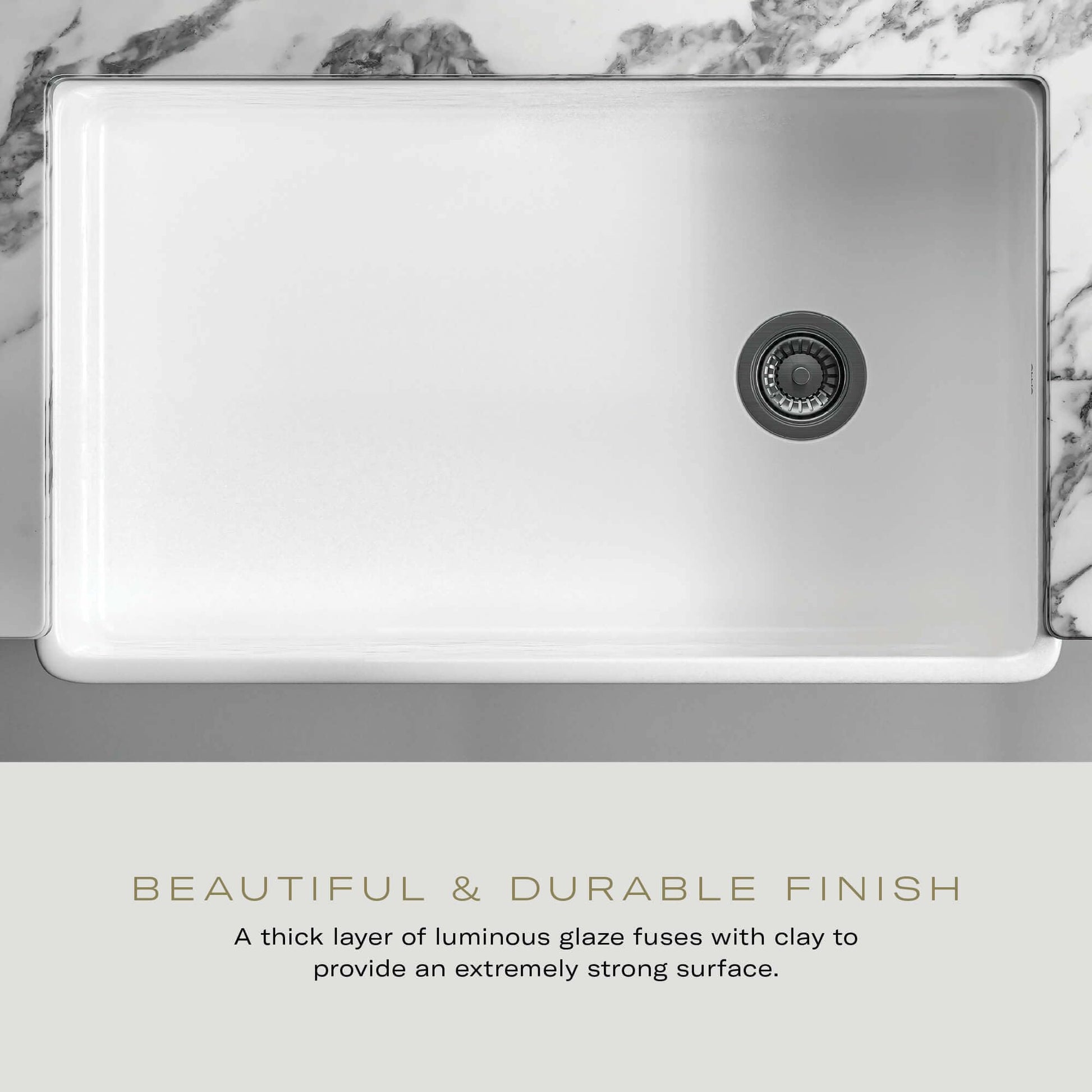 White fireclay undermount kitchen sink with rounded corners and single drain hole, viewed from above.
