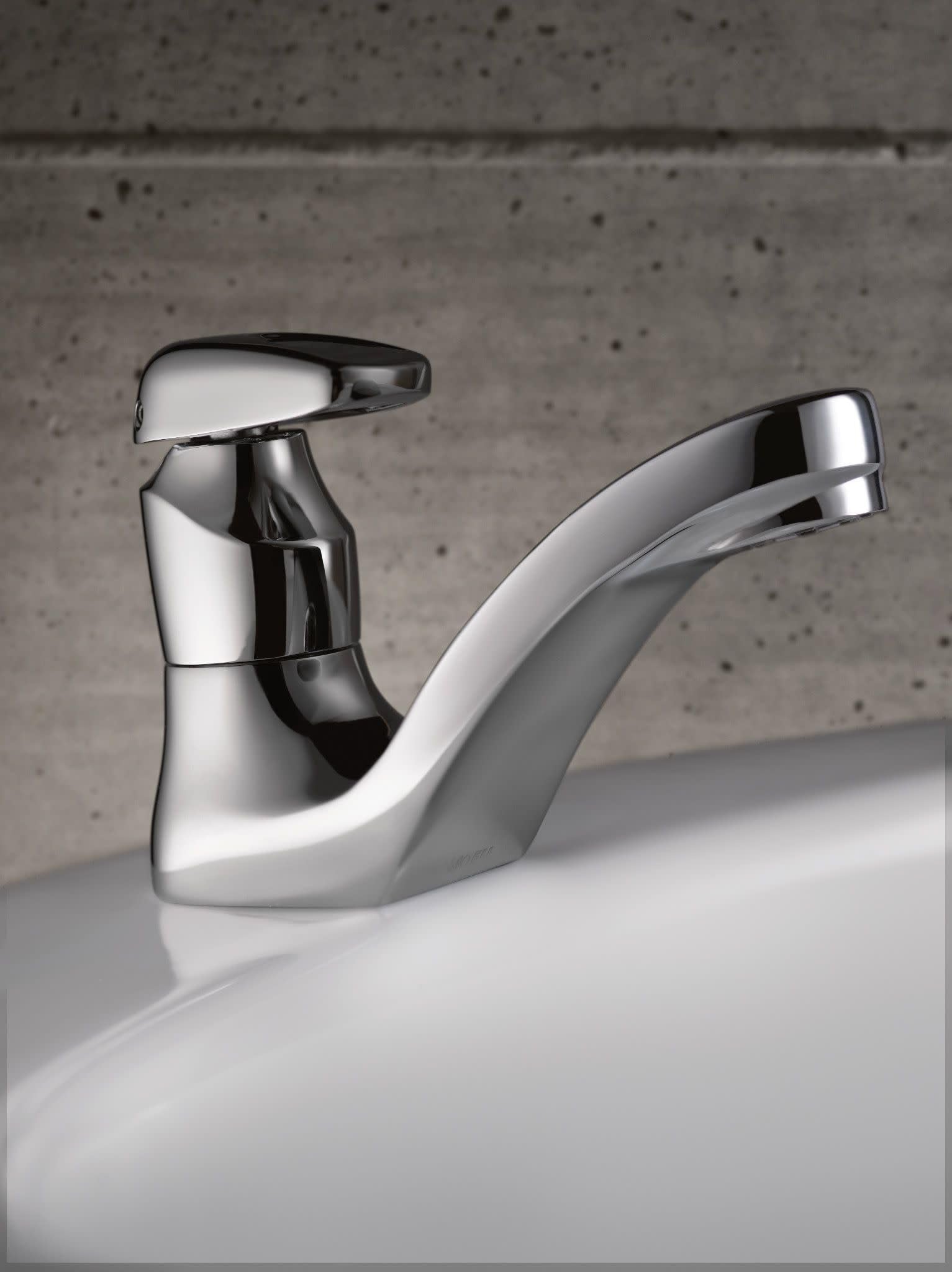 Chrome single-handle bathroom faucet with curved spout mounted on white sink basin.