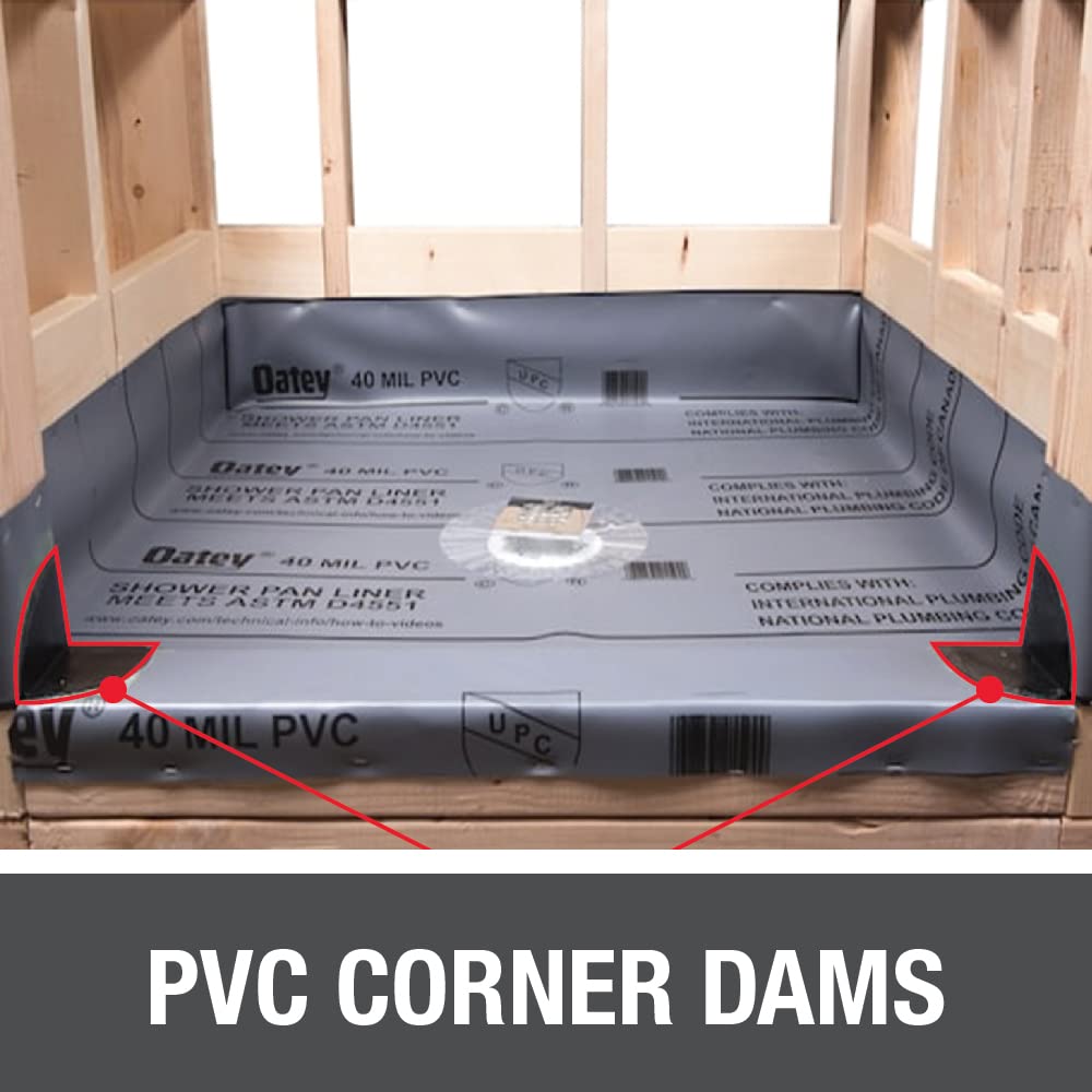 White PVC corner dams with red raised edges installed in shower pan opening with wooden framing visible.