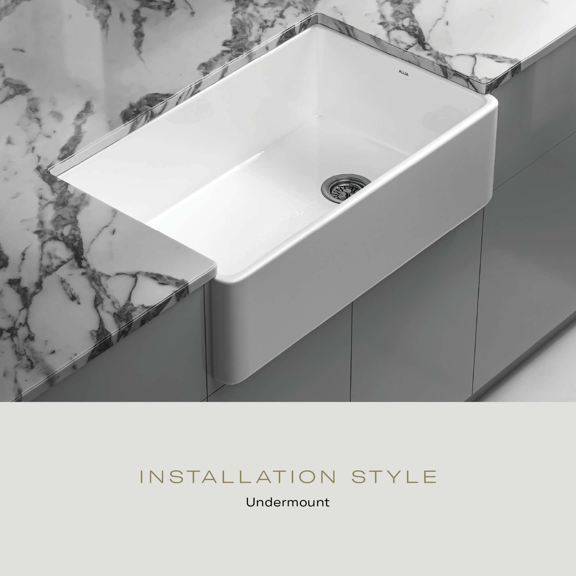 White rectangular fireclay sink with single basin and drain, installed undermount in marble countertop.