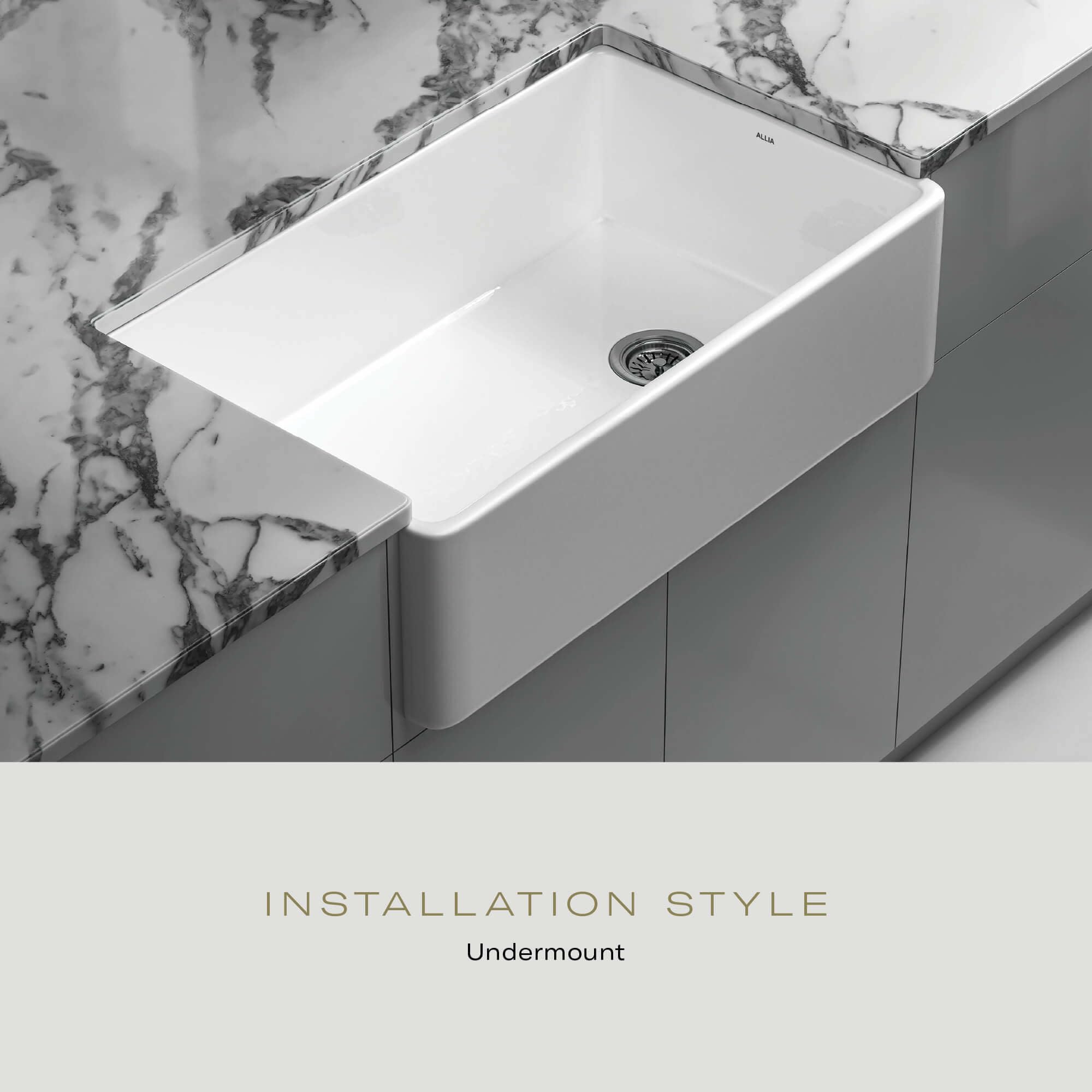 White rectangular fireclay sink with single basin and drain, installed undermount in marble countertop.