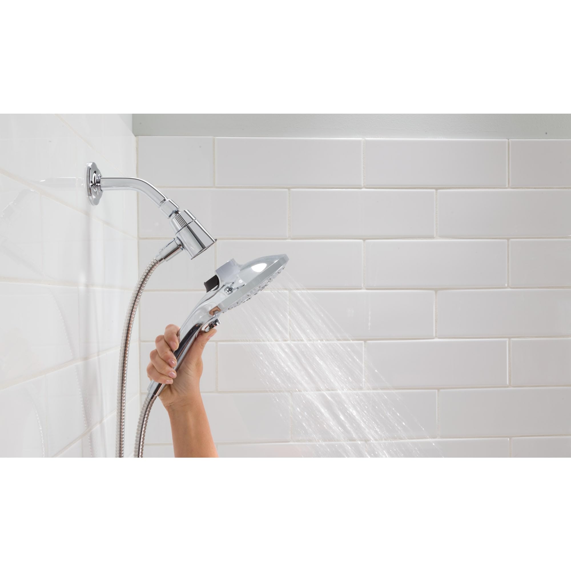 Brushed gold handheld showerhead with metal hose and wall-mounted docking system spraying water in shower.
