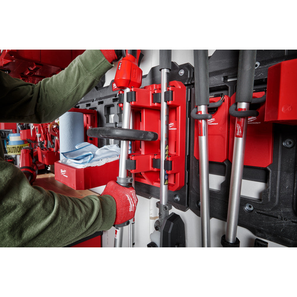 Red and black PACKOUT tool rack with metal handles mounted on storage system holding various tools and accessories.