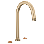 Gold widespread faucet with curved arc spout and pull-down spray head, shown with two copper-colored base inserts.