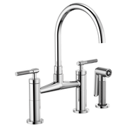 Chrome bridge faucet with curved arc spout, dual knurled handles, and detached side sprayer.