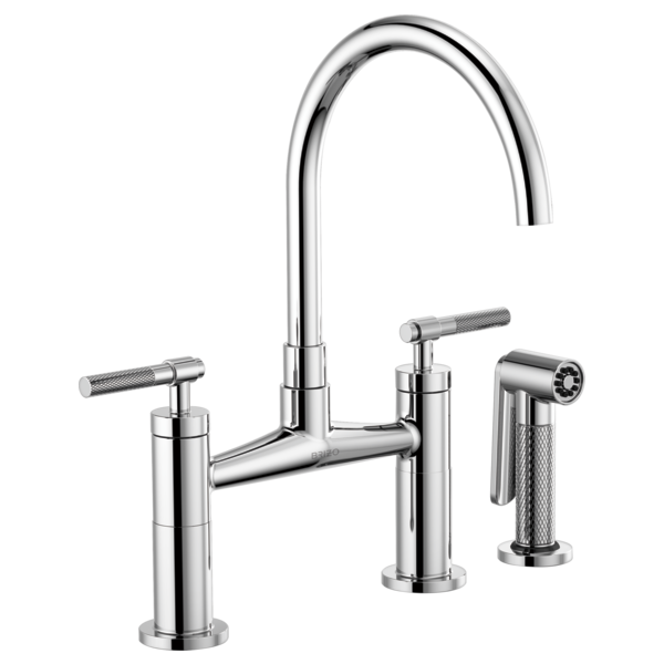Chrome bridge faucet with curved arc spout, dual knurled handles, and detached side sprayer.
