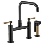 Matte black bridge faucet with square spout, two knurled bronze handles, and matching side spray.