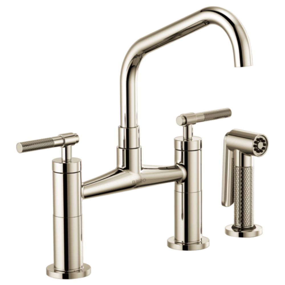Polished nickel bridge faucet with angled spout, dual knurled handles, and separate side spray.