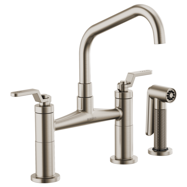 Stainless steel bridge faucet with curved spout, two lever handles, and matching side spray attachment.