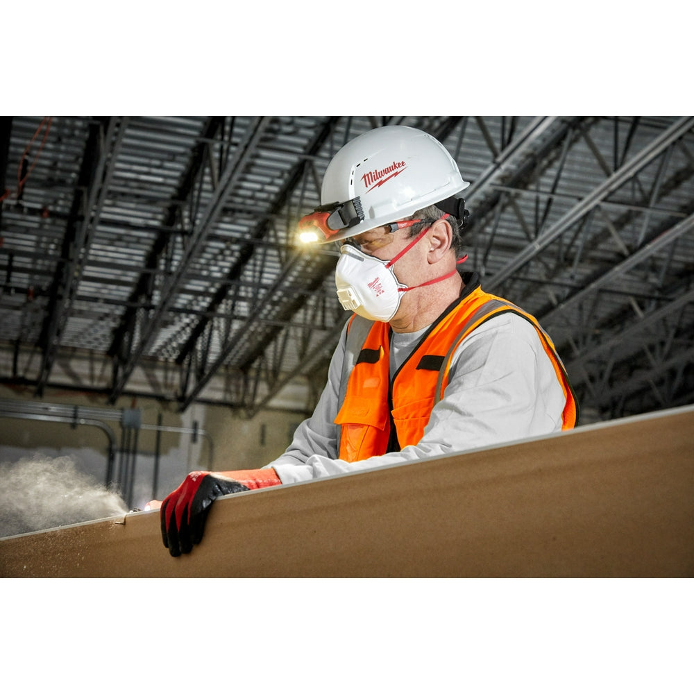 Worker wearing Milwaukee safety glasses with clear lenses and black frames on a job site.