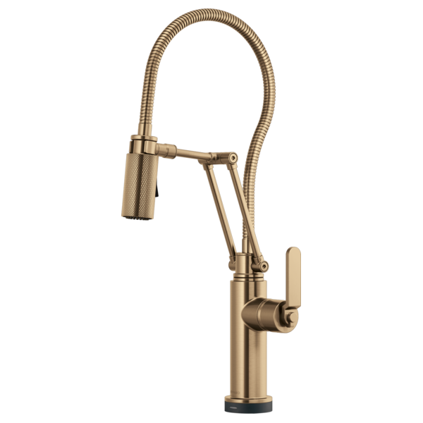 Brushed gold kitchen faucet with articulating spray head and coiled hose.