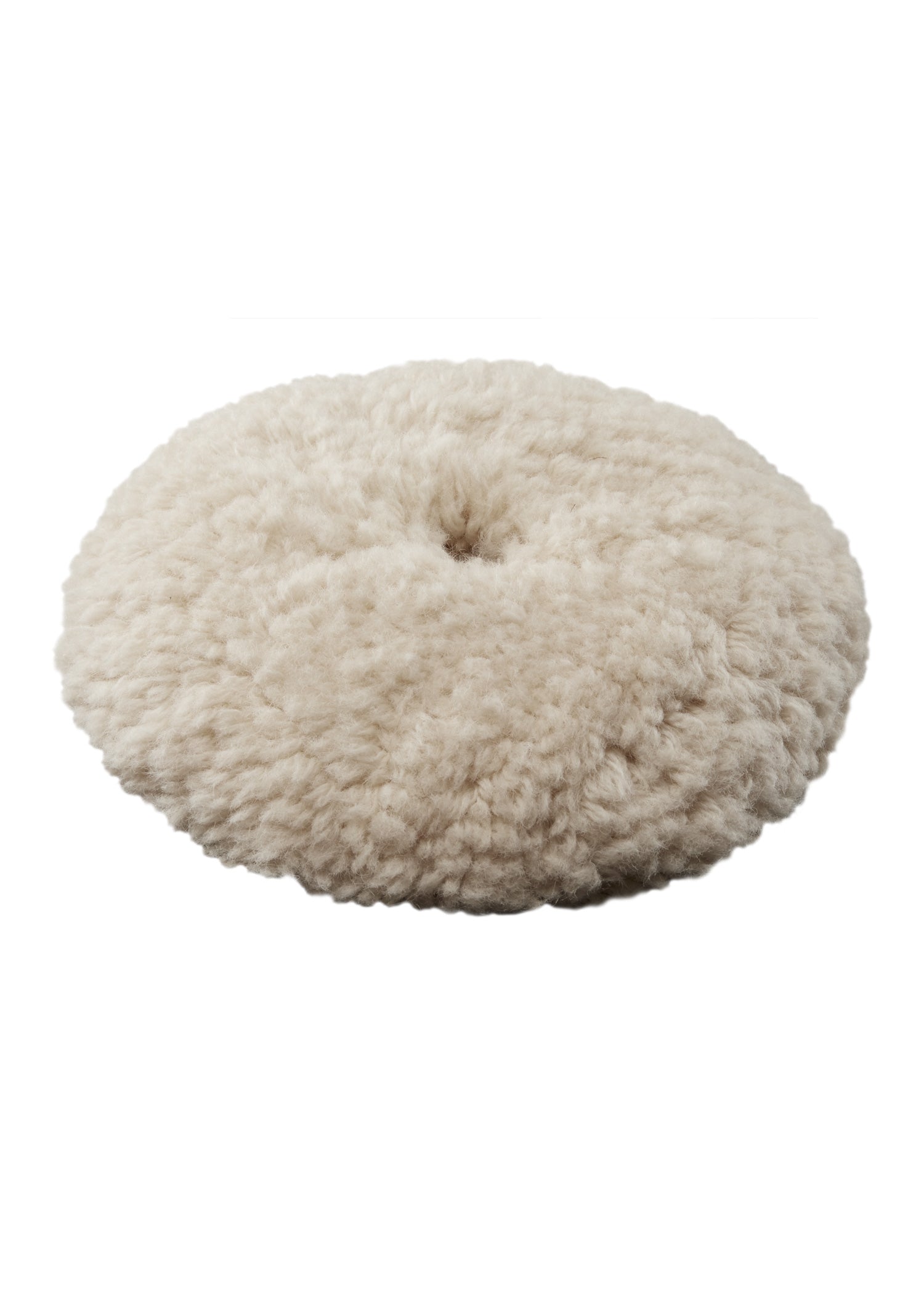 Round cream-colored wool cutting pad with dense pile and center hole for tool attachment.