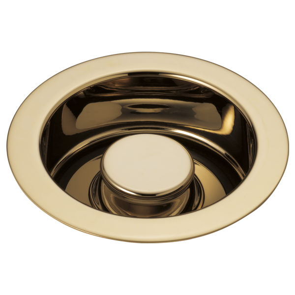 Polished brass circular disposal flange with cream-colored stopper button in center.