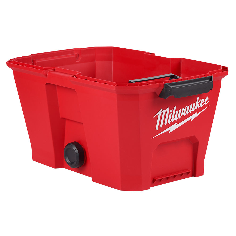 Red plastic vacuum tank with black handles and drain valve, Milwaukee branding on side.