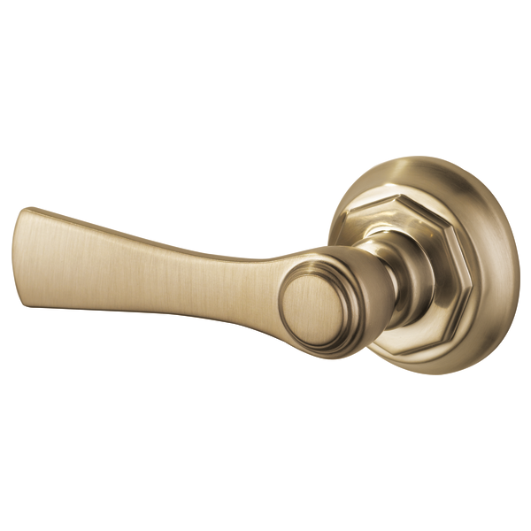 Brushed gold toilet flush lever with curved handle and circular mounting plate.