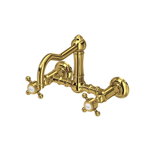 Wall-mounted bridge kitchen faucet in unlacquered brass with column spout and cross handles.