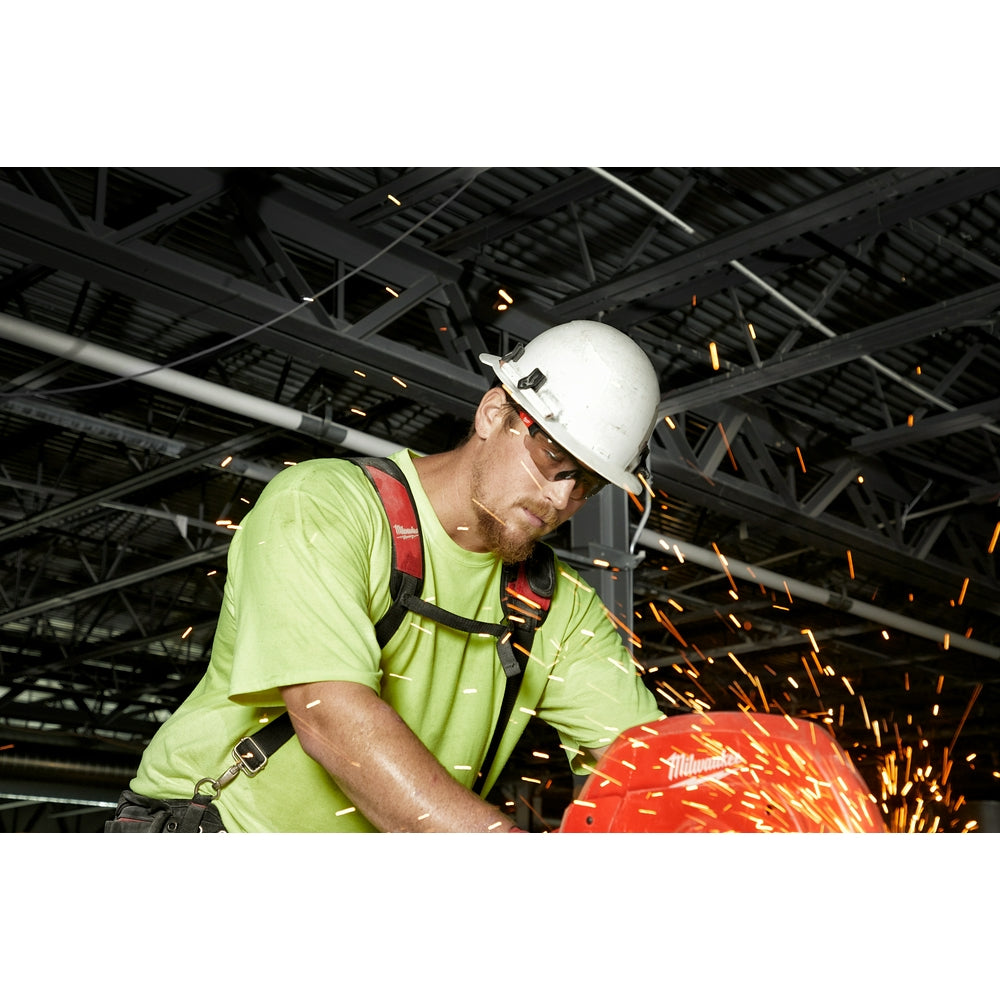 Worker wearing gray-tinted safety glasses while using a power tool with sparks flying.