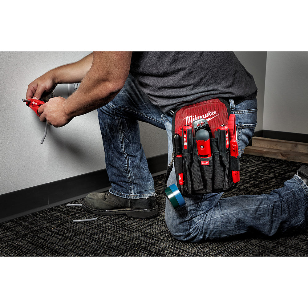 Red and black Milwaukee utility pouch worn on belt with multiple tool pockets and compartments.