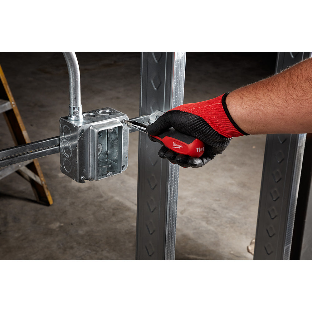 Milwaukee multi-bit screwdriver with red and black handle being used to install an electrical outlet box.