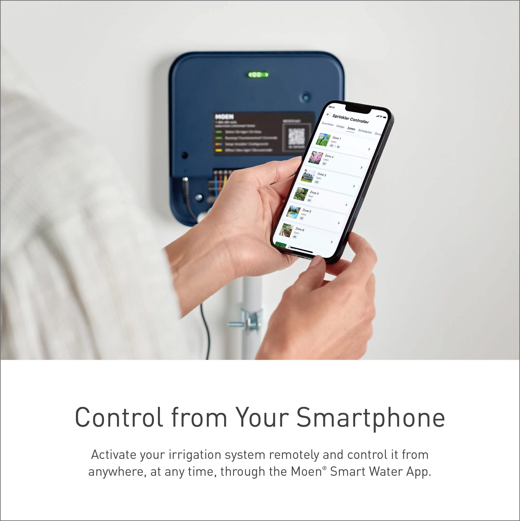 Blue Moen smart sprinkler controller mounted on wall with smartphone displaying sprinkler zone controls.