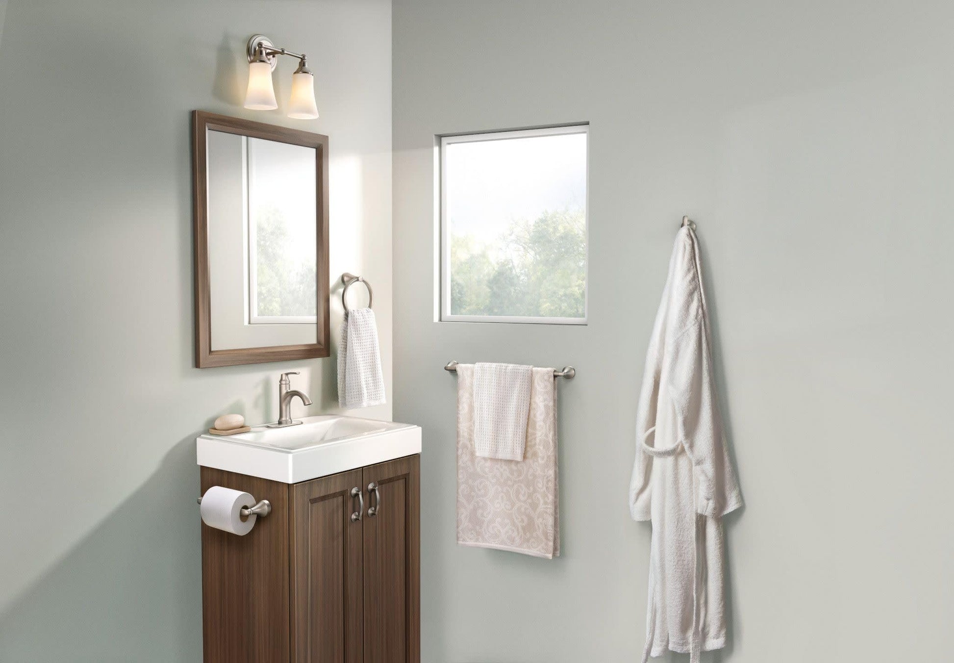 Brushed nickel bathroom accessory set including towel bars, toilet paper holder, and robe hook mounted on gray bathroom wall.