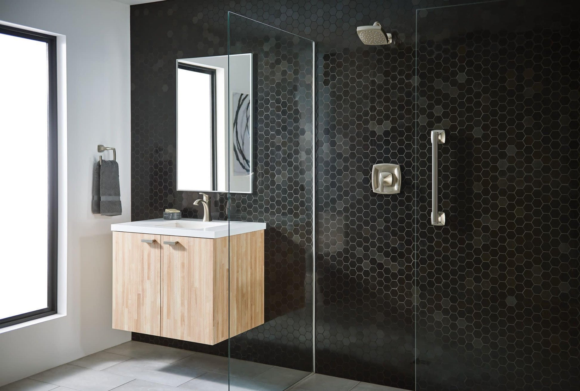 Brushed nickel single-handle bathroom faucet with high arc spout installed on white sink in modern bathroom setting.