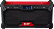 Black and red jobsite radio with Bluetooth controls, digital display showing 12:00, speaker grille, and carrying handles.