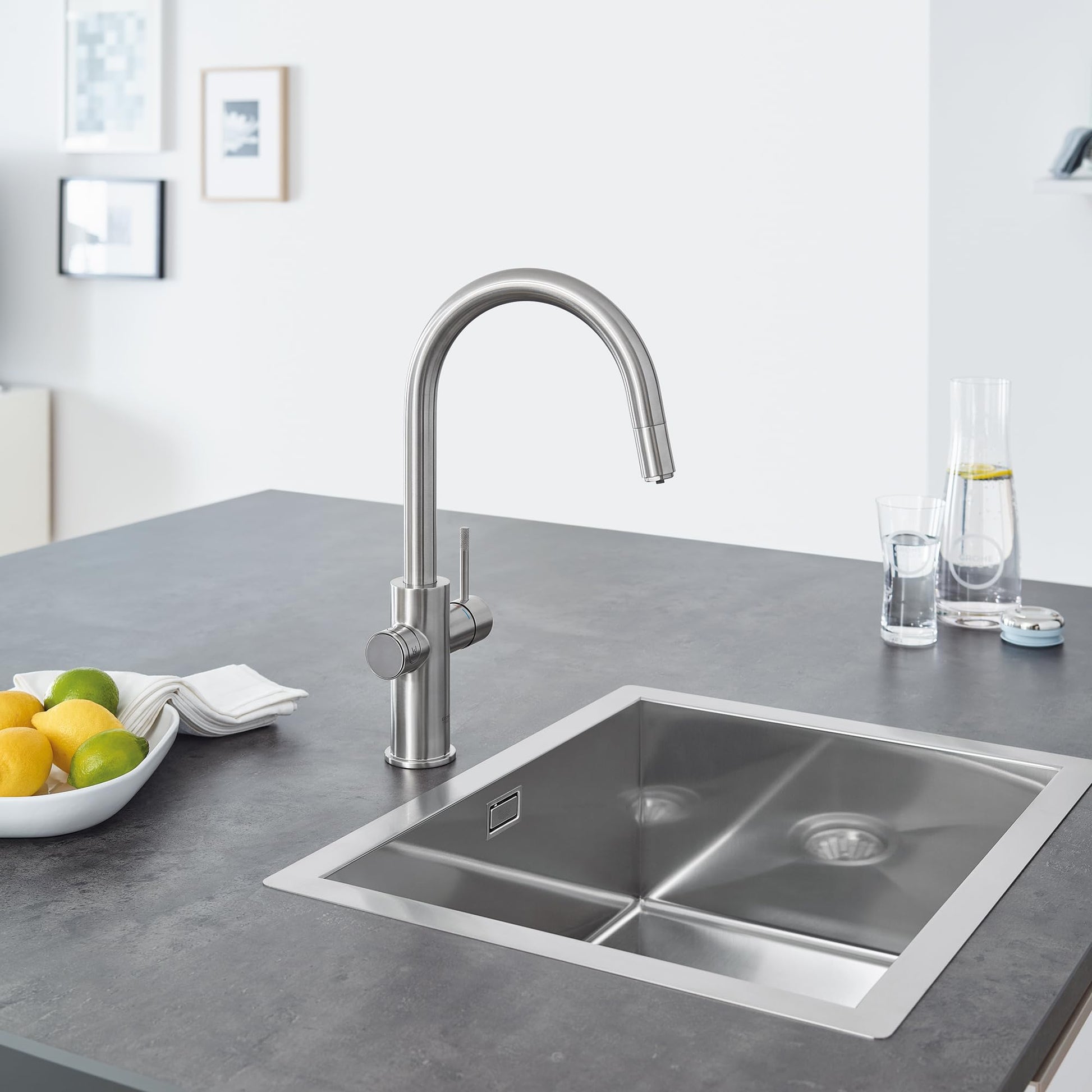 Stainless steel single-handle pull-down kitchen faucet with curved spout mounted above a double basin sink.