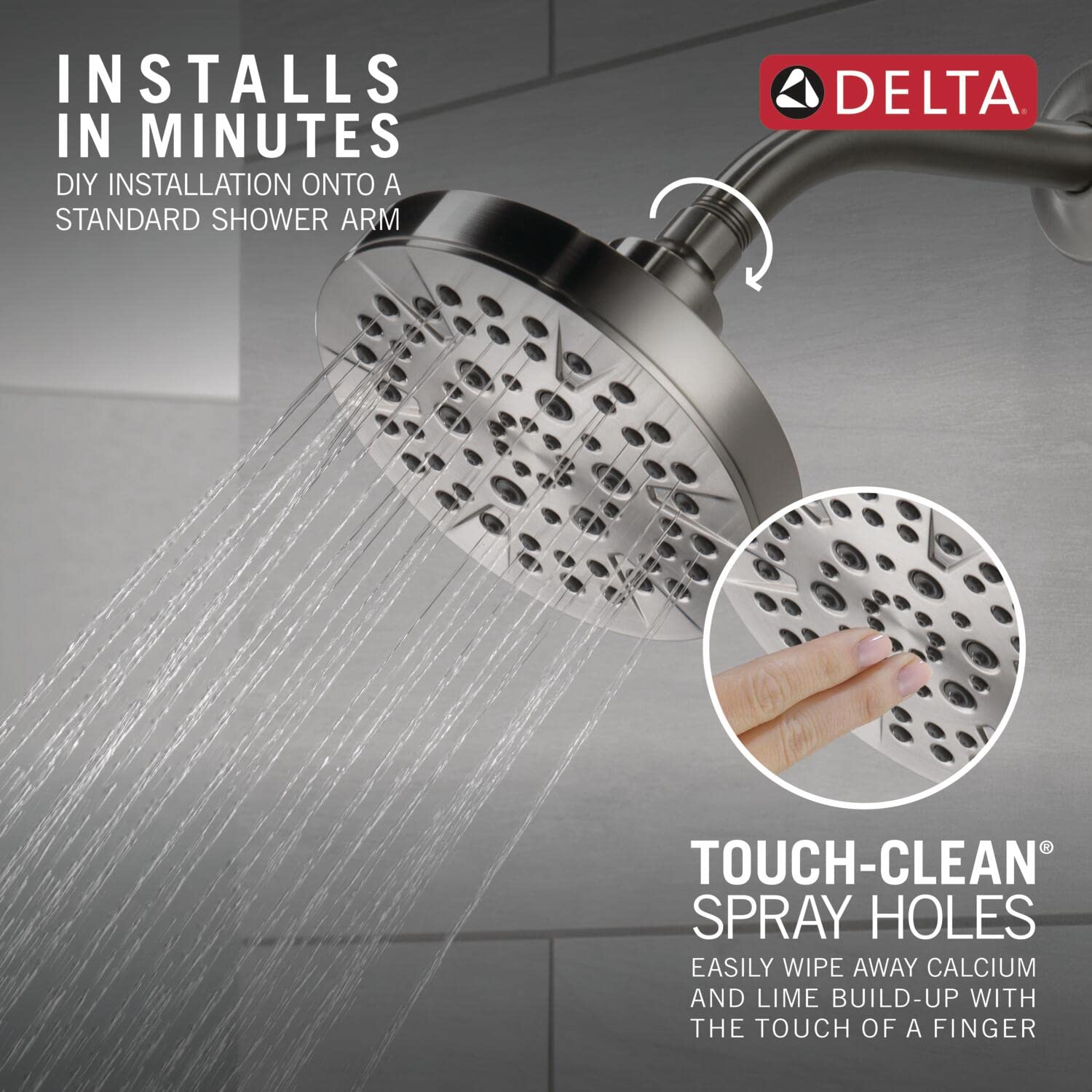 Chrome Delta shower head with multiple spray holes mounted on shower arm, water streams visible below.